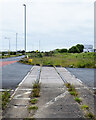 Abandoned, single railway track crossing roadway