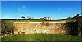 Sheep in field and Somerfield House behind curved wall formerly housing trough