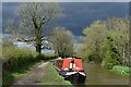 Red narrowboat under a stormy sky