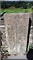 Boundary stone against stone wall on northwest side of Apperley Lane