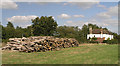 Log pile with Rose Cottages behind