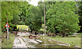 River Dove after bursting its banks and washing brick parapet into road.