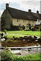 Wool: stream in front of thatched cottage