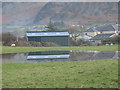 Farm shed reflected in flood water