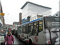 Bus passing tarpaulined building in London Road