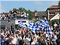 Flags wave as the wives and children pass