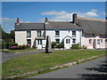 Stone cross and cottages at Mawgan-in-Meneage