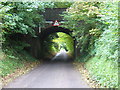 Road goes under disused railway bridge near Cocking